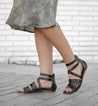 A woman wearing a Bed Stu Miya black leather sandals.