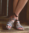 A woman wearing Bed Stu Miya gray leather sandals.
