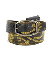 The Mohawk belt by Bed Stu features distressed leather adorned with a worn gold floral pattern and is equipped with a rectangular metal buckle.