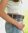 A woman wearing jeans and a Mohawk  Bed Stu brown belt.