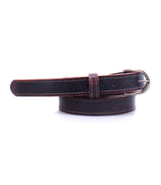 A rolled dark brown distressed leather belt from Bed Stu called the Monae, it features a silver buckle and contrasting white stitching, combining rustic charm with modern style.