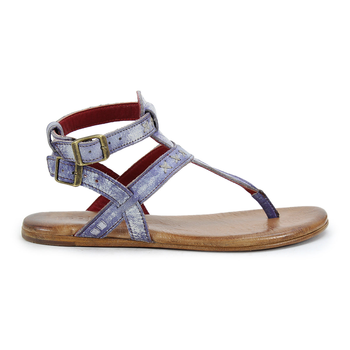 The side view of the Moon sandal by Bed Stu highlights its artisanal craftsmanship with metallic purple straps, two brass buckles, and a brown flat sole for unmatched comfort.