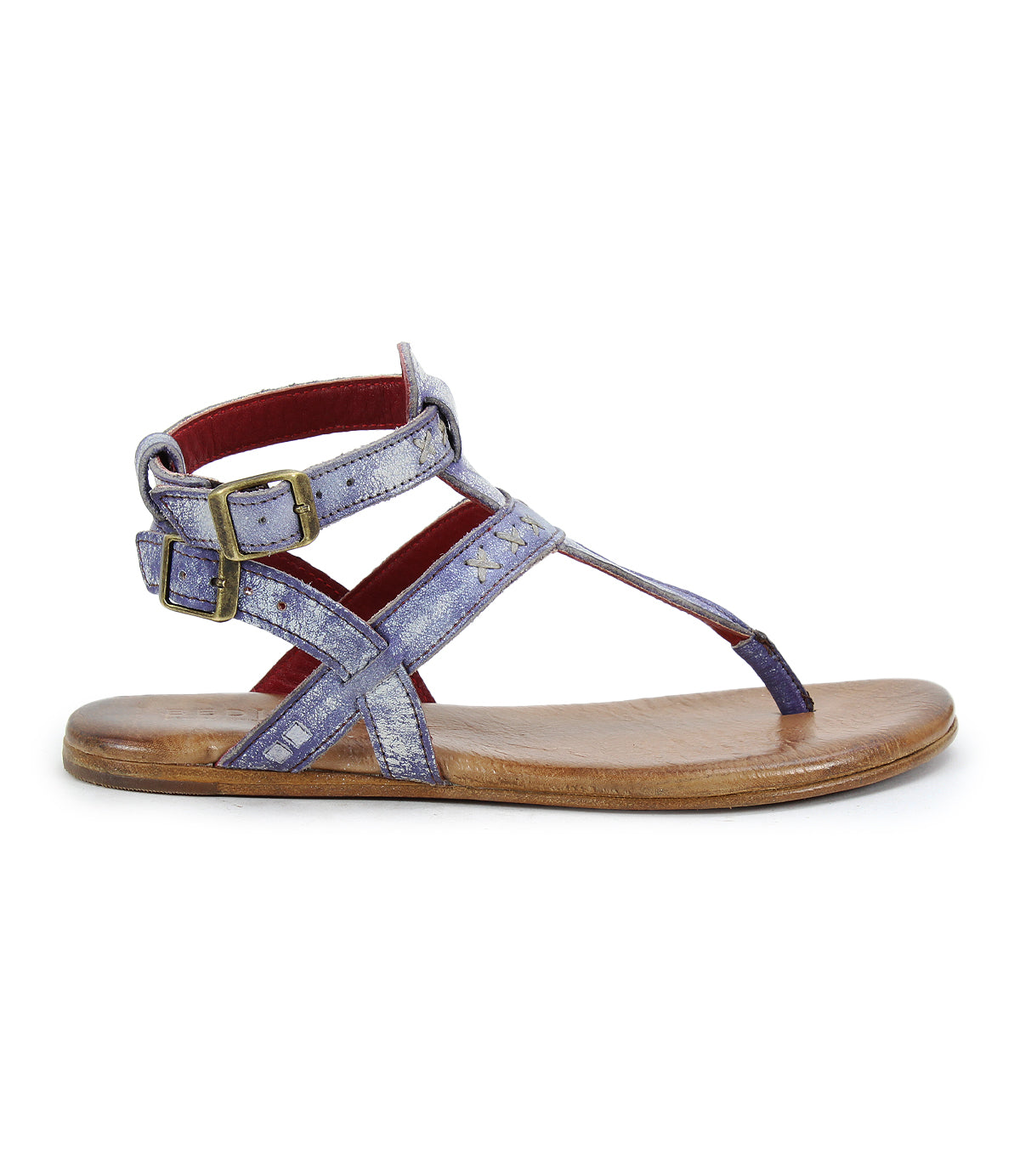 The side view of the Moon sandal by Bed Stu highlights its artisanal craftsmanship with metallic purple straps, two brass buckles, and a brown flat sole for unmatched comfort.