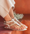 A woman's feet in white Bed Stu Moon sandals.