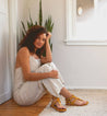 A woman sitting on the floor in a room with a Moon potted plant from Bed Stu.