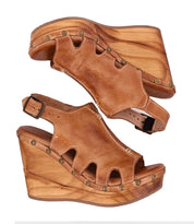 A pair of Naiya wedge sandals in tan by Bed Stu.