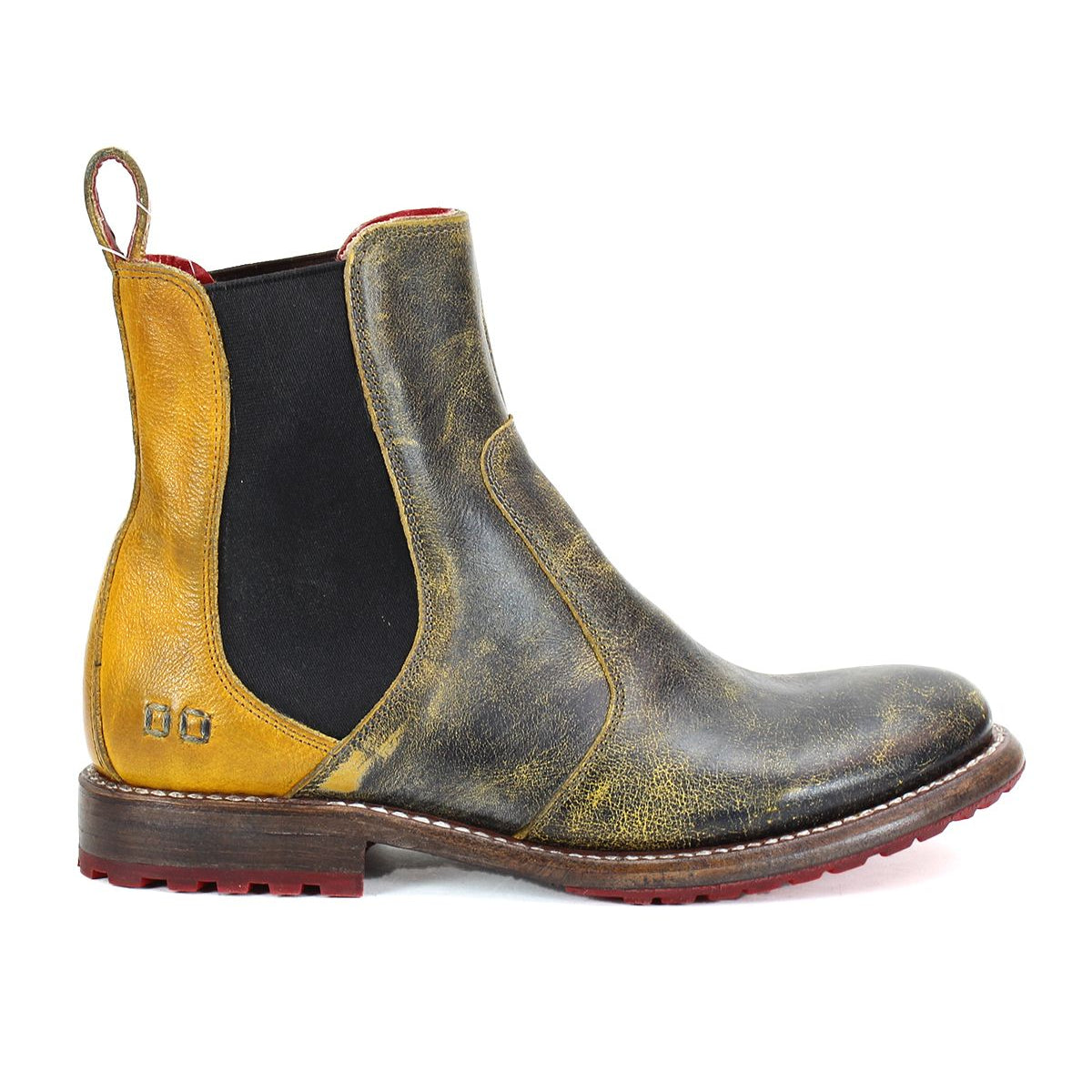 The Nandi by Bed Stu is a single leather Chelsea boot with a worn, vintage appearance, featuring elastic side panels and a pull tab at the back. This stylish piece of women's footwear showcases a brown and yellow color scheme with a striking red sole. Perfect for any woman looking to add fashionable boots to her collection.