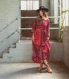 A woman wearing a red paisley dress and Bed Stu Nandi chelsea leather boots.