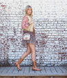 A woman in Nivi boots standing in front of a brick wall wearing Bed Stu.