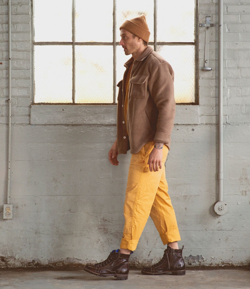 A man wearing Bed Stu yellow pants and a Bed Stu beanie