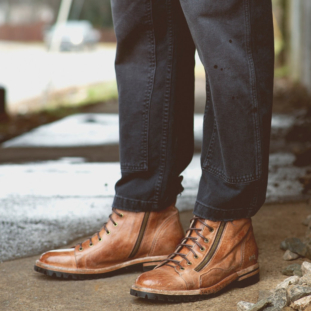 A man wearing a pair of Bed Stu Old Bowen Trek brown leather boots.