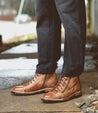 A man wearing a pair of Bed Stu Old Bowen Trek brown leather boots.