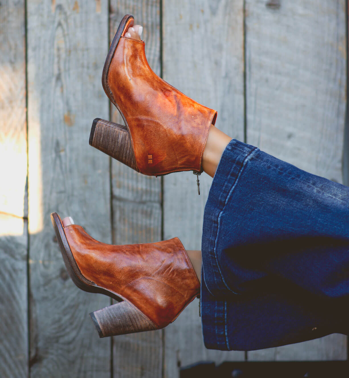 A woman's legs in a pair of Bed Stu Onset brown leather boots.