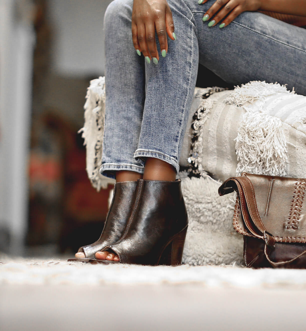 A woman sitting on a couch holding an Onset purse from Bed Stu.