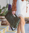 A woman wearing a skirt and Bed Stu Orchid L purse.