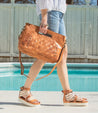 A woman wearing Bed Stu Orchid L sandals and a tan woven bag.