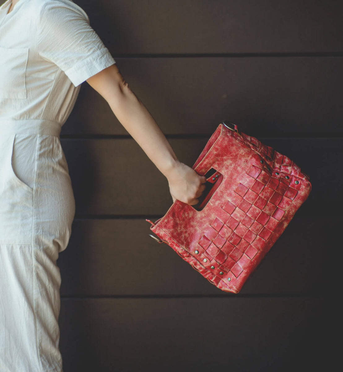 A woman is holding a red Bed Stu Orchid bag.