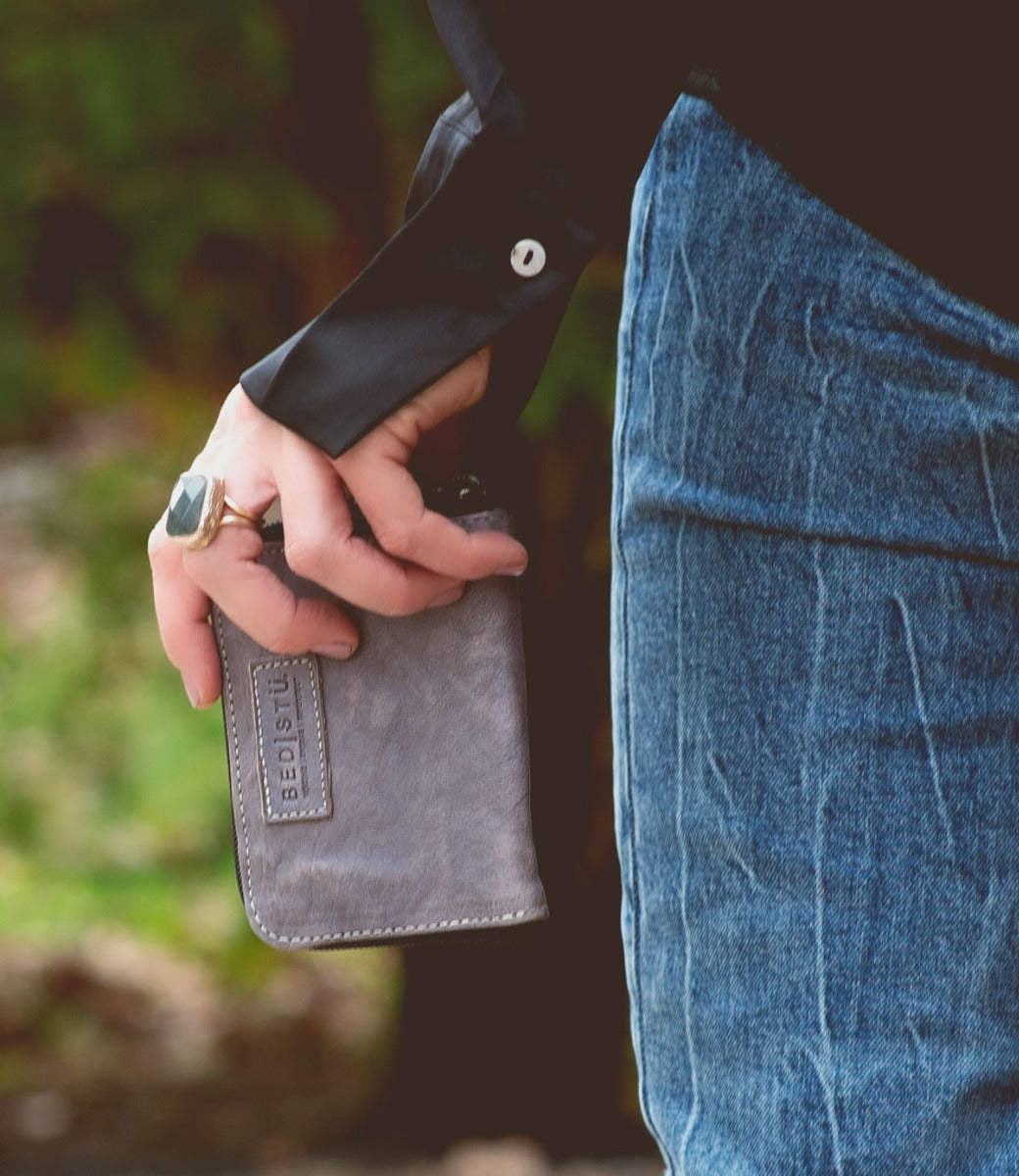 A person holding a Bed Stu Ozzie wallet in their hands.