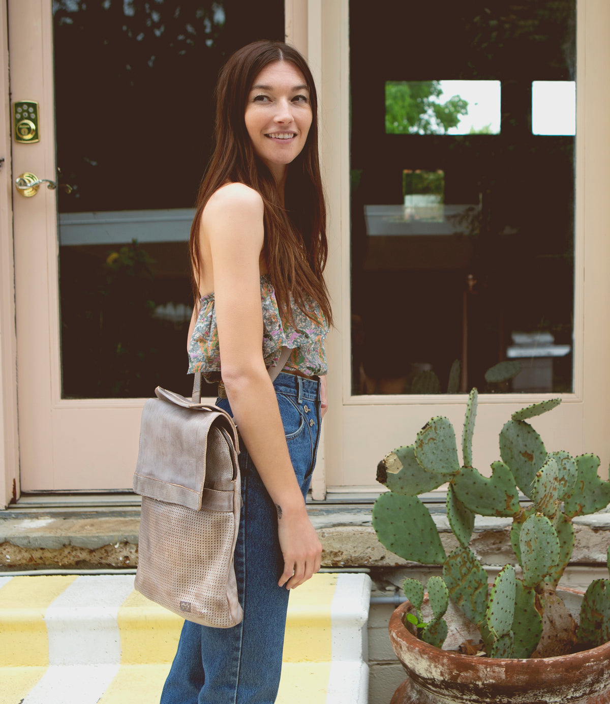 A young woman standing in front of a Patsy cactus from Bed Stu.