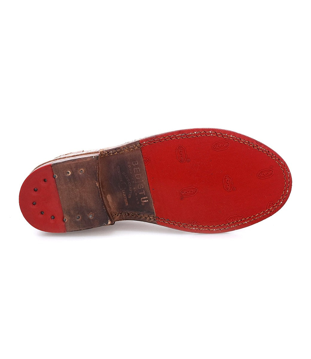 A pair of Bed Stu Plio shoes with red soles on a white background.