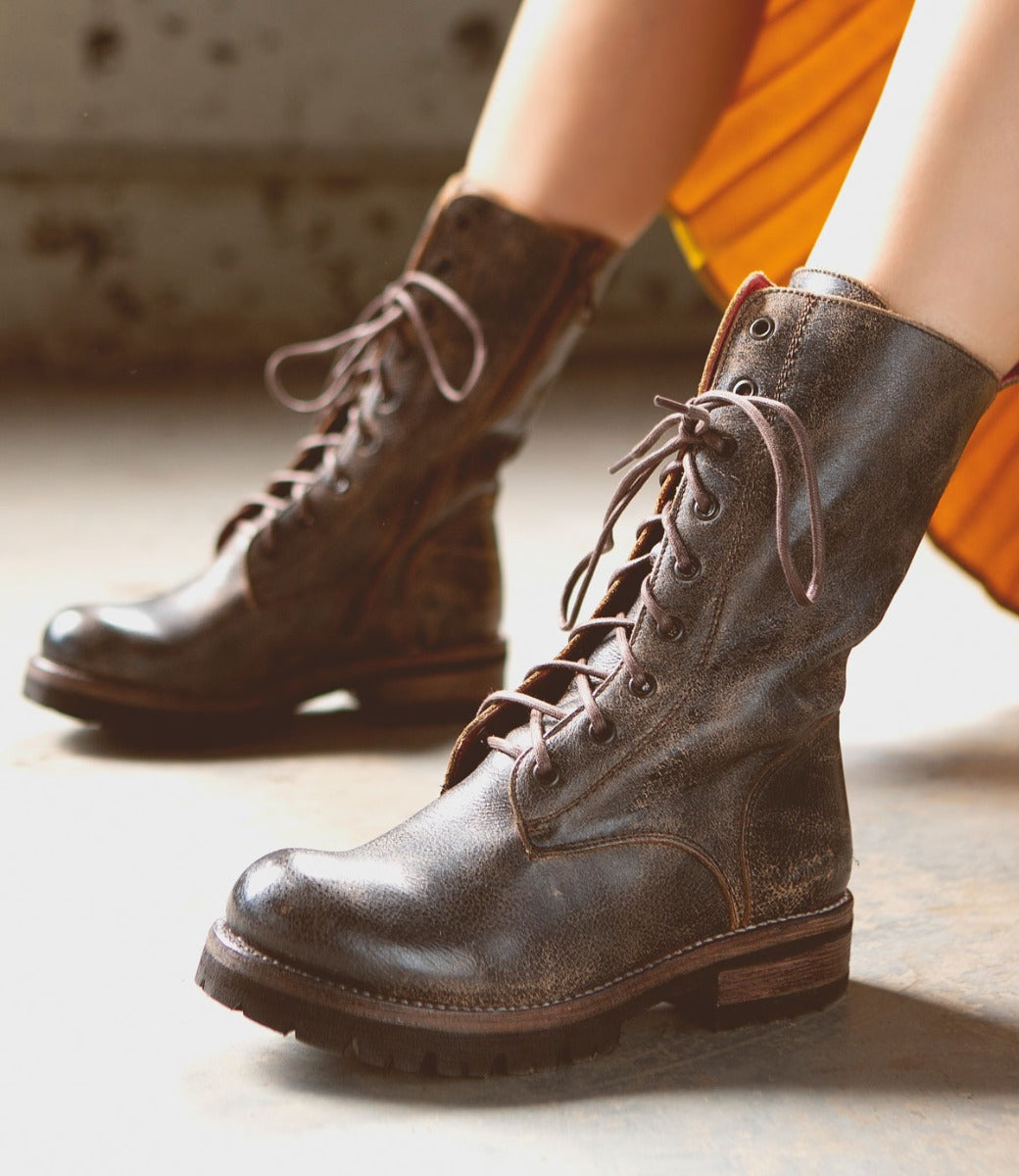 A pair of women's Posh brown combat boots by Bed Stu on a concrete floor.