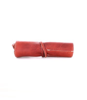 A rolled-up brown leather pouch secured with a leather strap, featuring visible stitching along the edges, perfect for storing artist tools. This exquisite piece, the Prepped Leather Wrap from Bed Stu, can be found at the Leather Shoppe.