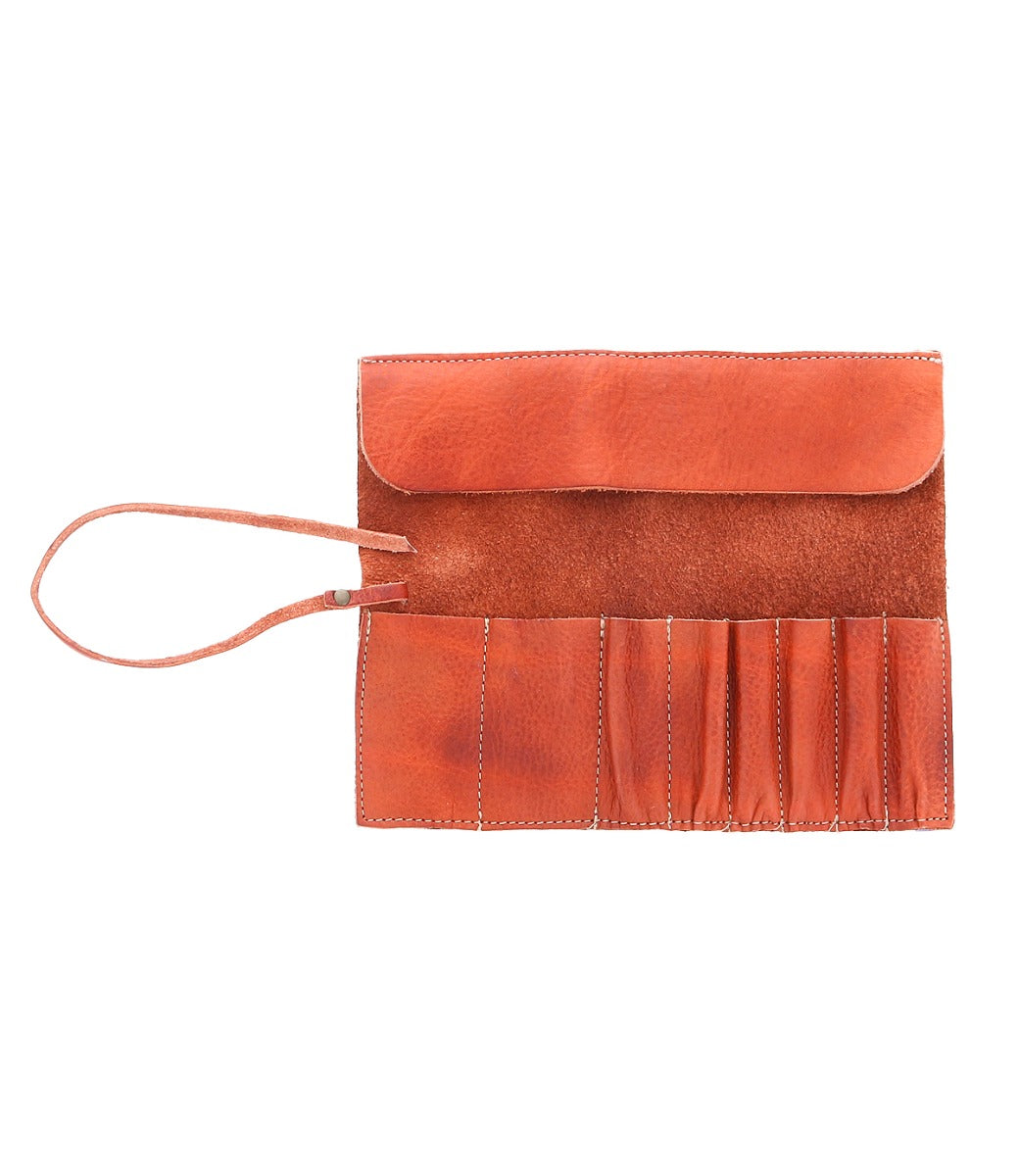 A brown leather pouch, resembling the Prepped Leather Wrap by Bed Stu, with a flap and multiple slots unfolds to display its contents, attached by a single strap. Ideal for organizing artist tools, it’s crafted with care from the finest materials at our Leather Shoppe.