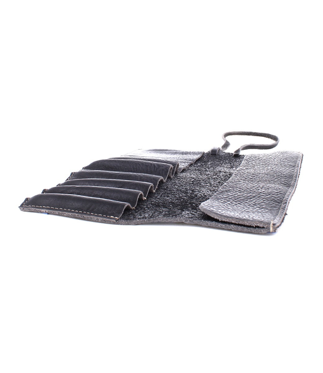 An open black leather Prepped Leather Wrap from Bed Stu, featuring multiple compartments and a secure strap, perfect for organizing artist tools.
