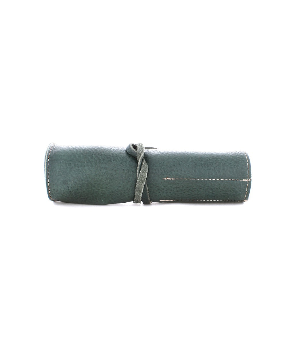 A rolled-up, green Prepped Leather Wrap tied with a matching leather strap from Bed Stu, featuring visible white stitching.