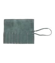 A green leather Prepped Leather Wrap from Bed Stu with multiple slots and a handle strap, perfect for organizing artist tools.