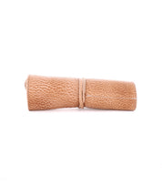 A rolled-up piece of textured, light brown Prepped Leather Wrap secured with a matching tie against a white background—a perfect addition to any Bed Stu's collection.