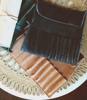 Several Prepped Leather Wraps in different colors are placed on a round, woven, off-white table mat, showcasing the fine craftsmanship of Bed Stu.