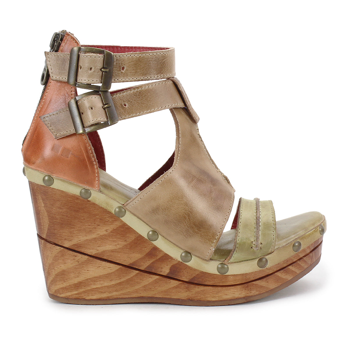 The Bed Stu "Princess" is a sustainable wooden wedge sandal featuring woven strappy uppers, tan leather straps, metal studs, and a double ankle buckle system.
