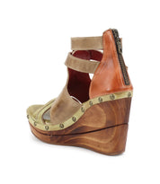The Bed Stu Princess sandal is a brown leather wedge featuring a double ankle buckle, woven strappy uppers, stud accents, and a convenient back zipper. A sustainable wooden platform heel rounds out the design.