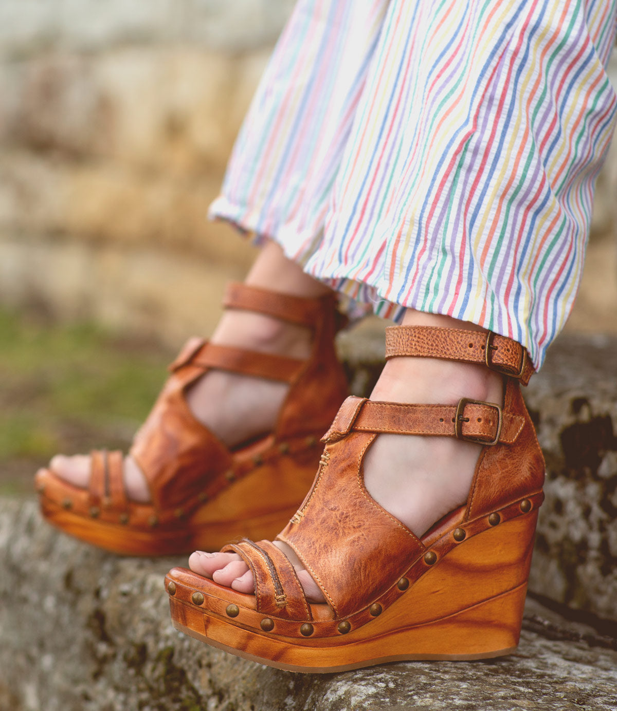 A woman wearing a pair of Bed Stu Princess brown wedge sandals.