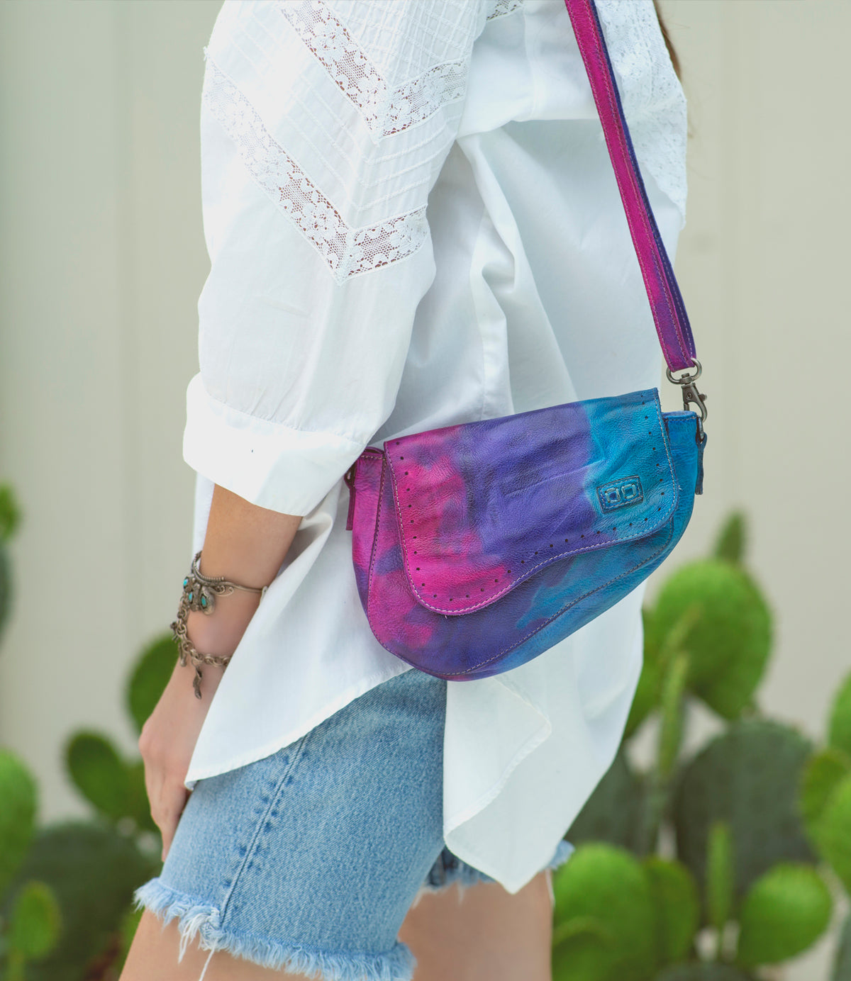 A woman wearing shorts and a Priscilla tie dye bag by Bed Stu.