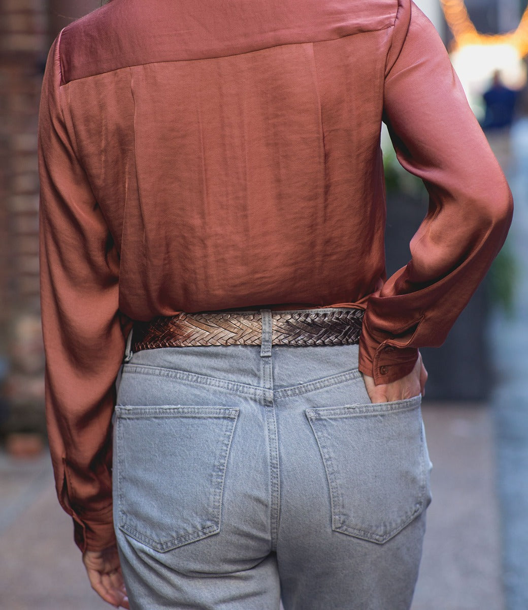 A woman wearing a braided leather belt with a metal buckle, the Proem by Bed Stu.