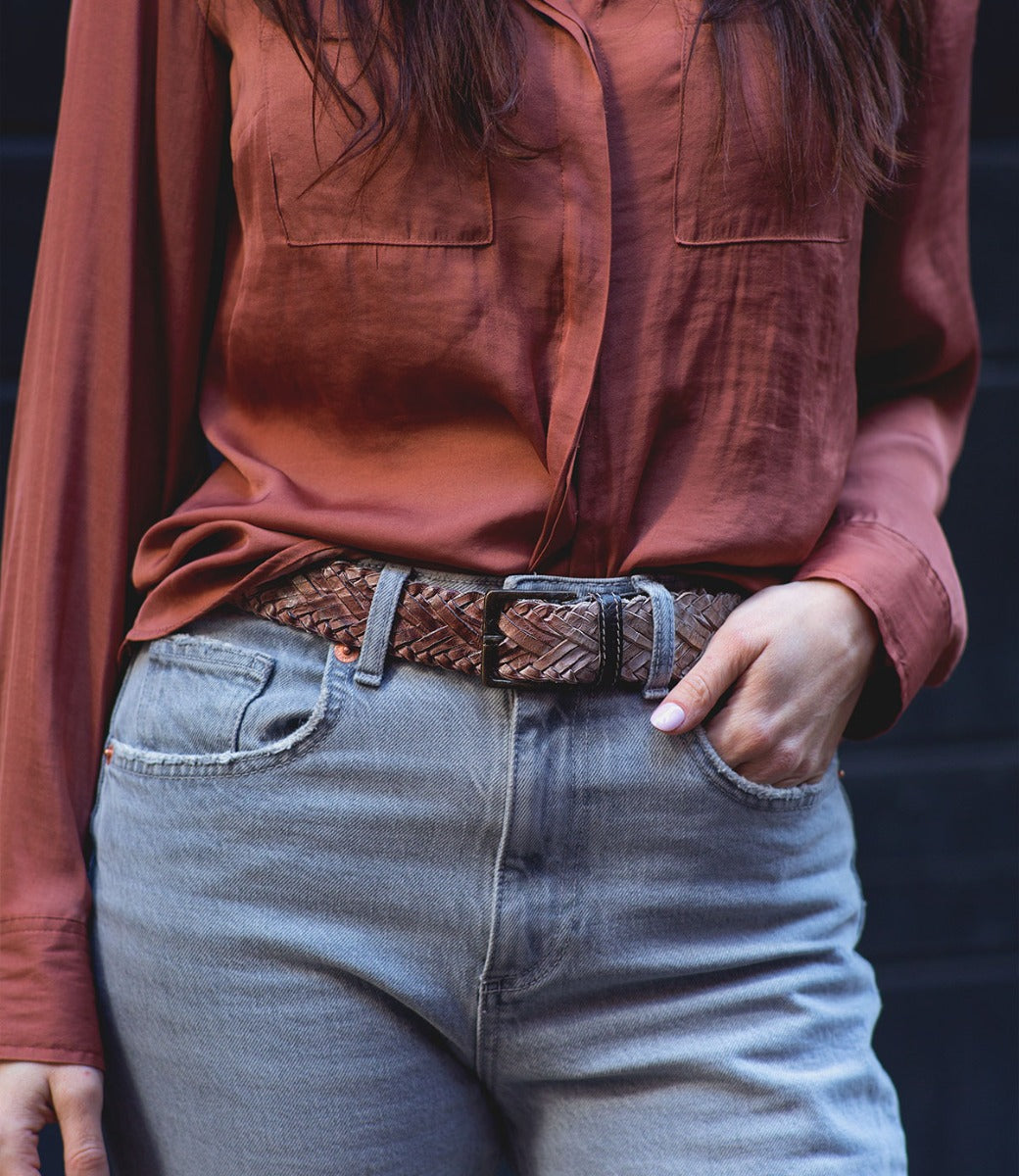 A woman wearing a braided leather belt with a metal buckle, the Proem by Bed Stu.