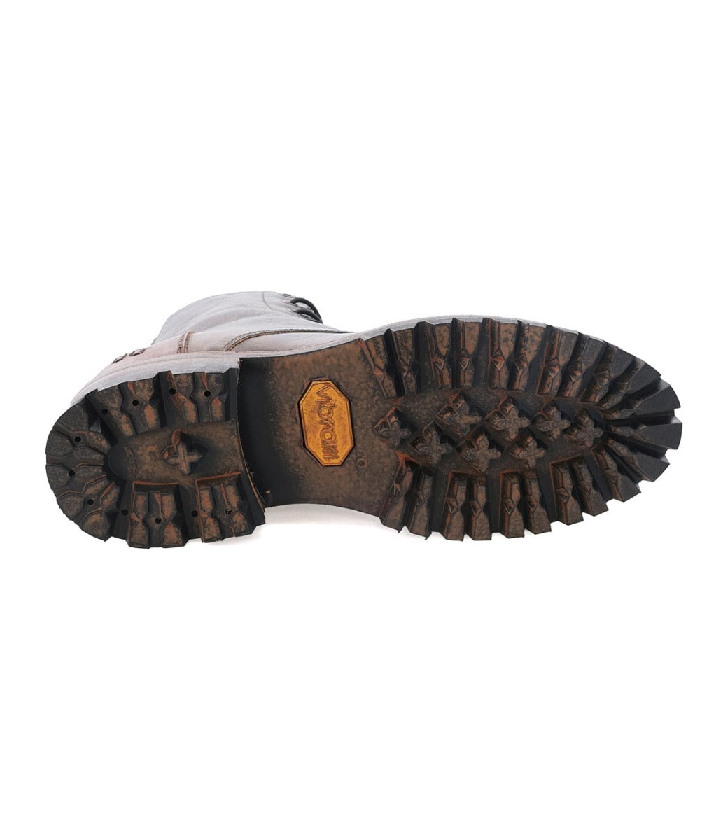 Bottom view of a worn hiking boot showing detailed tread pattern and a visible Bed Stu Vibram outsole on the heel.