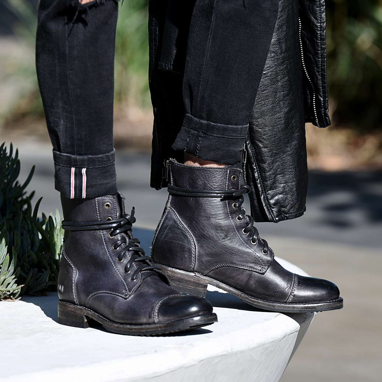 A person wearing a pair of Bed Stu Protege grey leather boots.