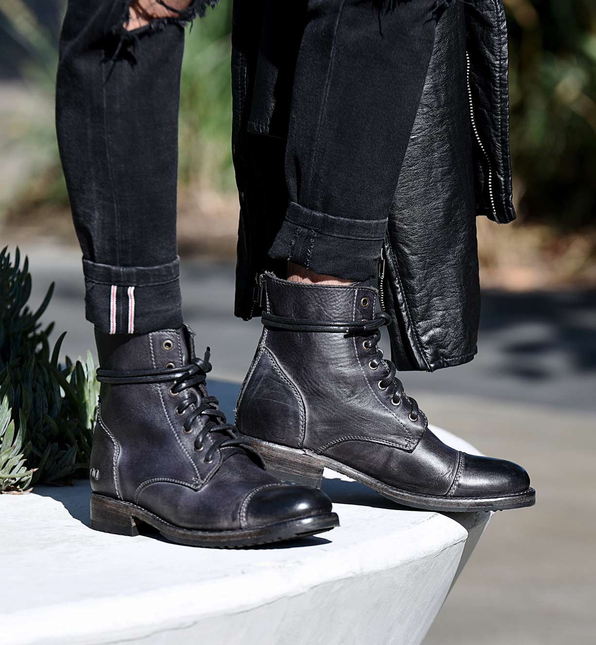 A person wearing a pair of Bed Stu Protege grey leather boots.