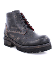 A women's black leather boot with a red sole, called the Quatro III by Bed Stu.
