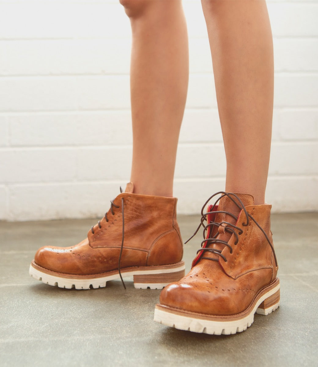 A woman wearing a pair of Bed Stu Quatro III brown lace up boots.