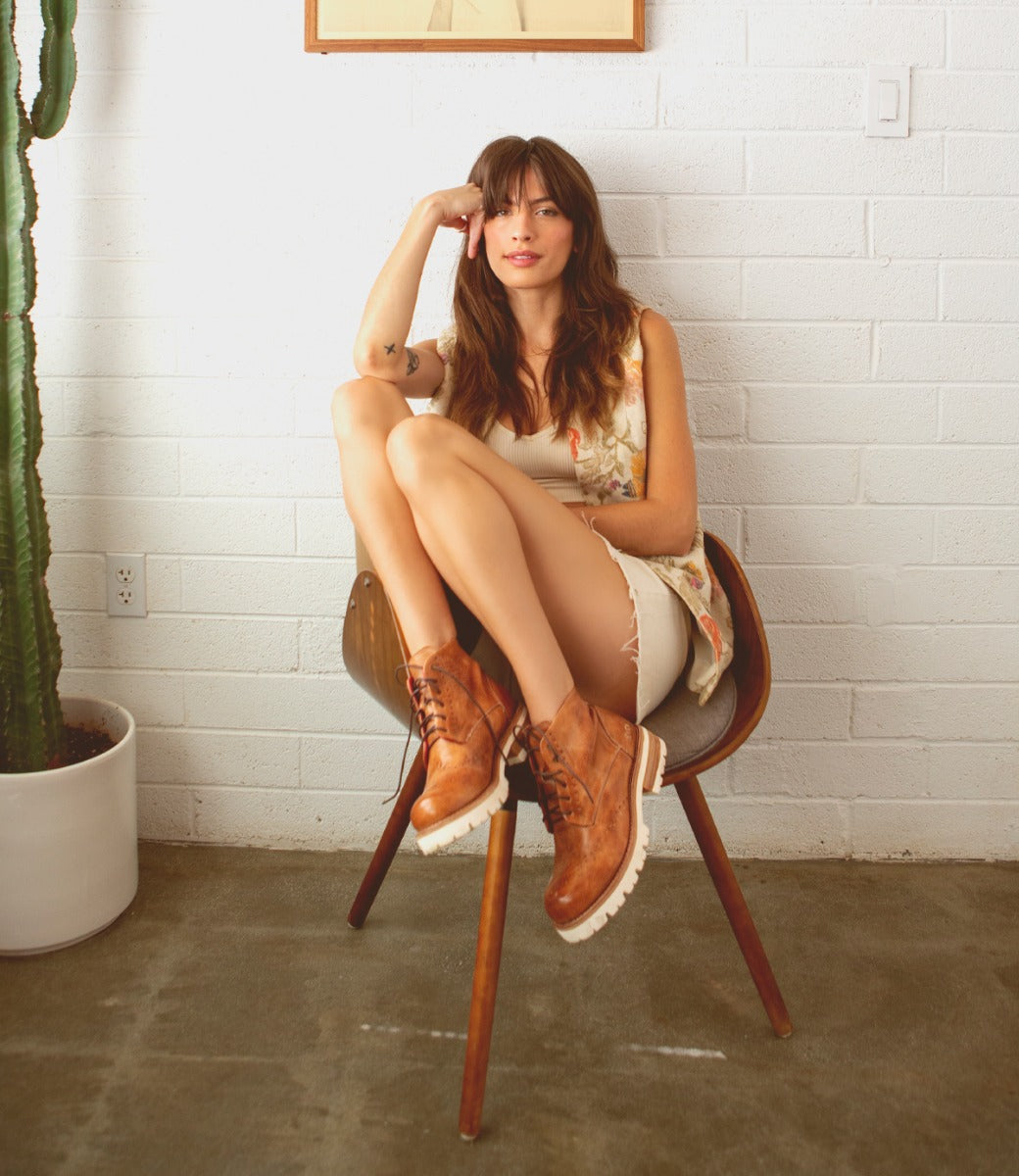 A woman sitting on a chair next to a Bed Stu Quatro III.