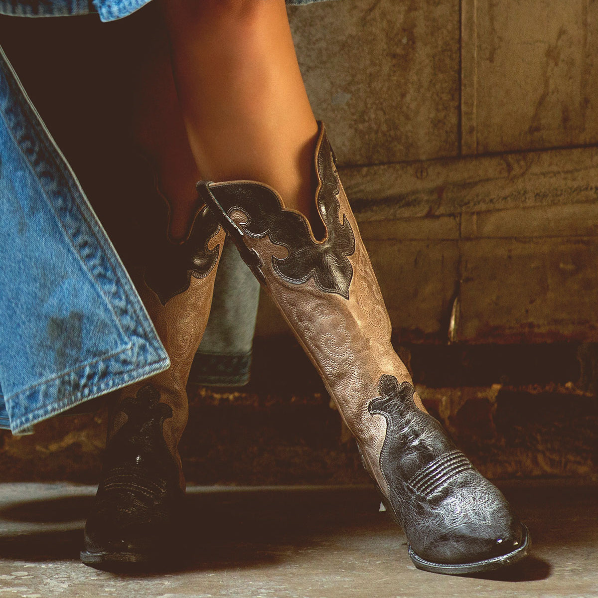 A fashionable Bed Stu Queen wearing tall cowboy boots and a denim skirt.