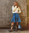 A Bed Stu queen-like woman rocking tall boots and a denim skirt in true western-style.