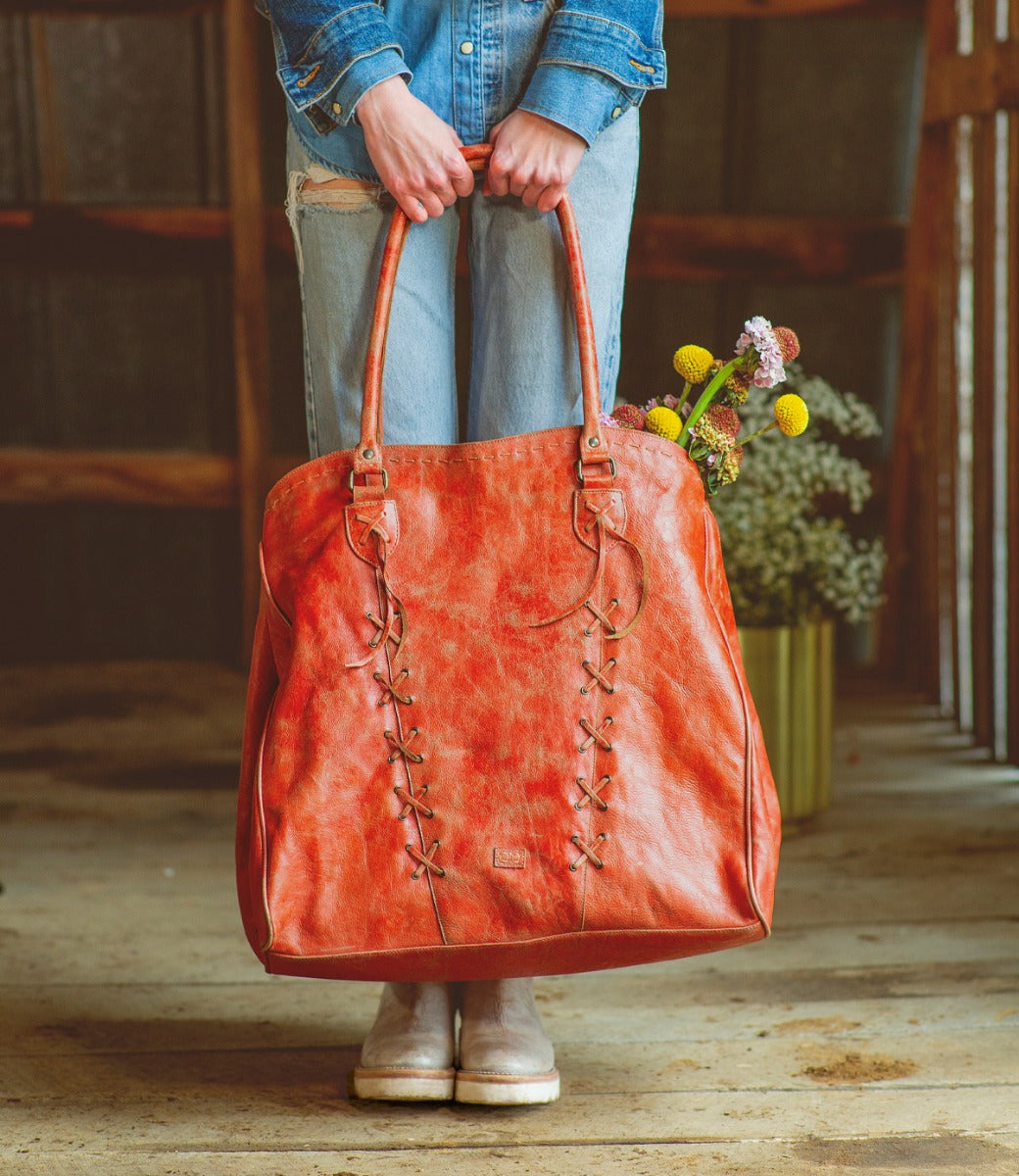 A woman carrying a Rebekah tote bag made by Bed Stu.