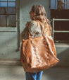 A woman carrying a Rebekah tote bag made by Bed Stu.