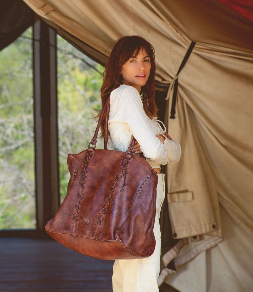 A woman carrying a Rebekah tote bag made by Bed Stu.