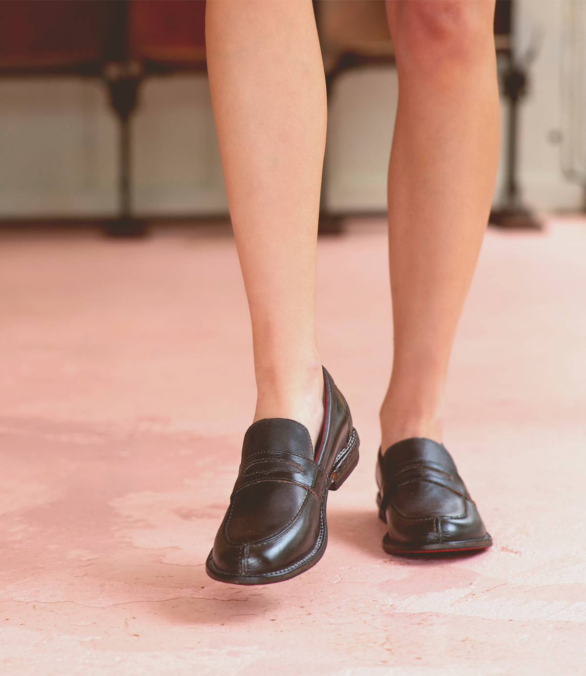 A woman's legs are standing on a Reina shoes by Bed Stu.